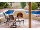 Inviting backyard with a cozy fireplace, outdoor seating, and pool at 23236 N Caleta Ct, Sun City West, AZ 85375