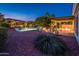 Tranquil backyard view highlighting a pool, a covered patio with seating, and meticulously landscaped desert surroundings at 23236 N Caleta Ct, Sun City West, AZ 85375