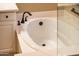 Soaking tub with black faucet in a relaxing bathroom, enclosed by glass and featuring a vanity at 23236 N Caleta Ct, Sun City West, AZ 85375