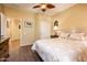 Bedroom with a ceiling fan, an ensuite bathroom and closet, with neutral colors, and wood look flooring at 23236 N Caleta Ct, Sun City West, AZ 85375