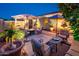 Exterior courtyard featuring comfortable seating, a fountain, and a fire pit under the night sky at 23236 N Caleta Ct, Sun City West, AZ 85375