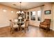 Bright dining area with a glass table, upholstered chairs, and a classic chandelier at 23236 N Caleta Ct, Sun City West, AZ 85375