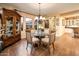 Elegant dining area with a glass table, upholstered chairs, and a chandelier centerpiece at 23236 N Caleta Ct, Sun City West, AZ 85375