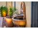 Outdoor fountain with potted plants in the background offers a serene ambiance in this home's outdoor space at 23236 N Caleta Ct, Sun City West, AZ 85375