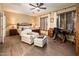 Comfortable main bedroom featuring a desk, chair, white chaise and ceiling fan at 23236 N Caleta Ct, Sun City West, AZ 85375