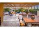 Inviting outdoor living space featuring a covered patio, outdoor dining set, and fireplace near a sparkling pool at 23236 N Caleta Ct, Sun City West, AZ 85375