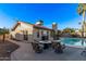 Outdoor oasis featuring a sparkling pool, comfortable seating around a fire pit, and lush landscaping at 26405 S Lakewood Dr, Sun Lakes, AZ 85248