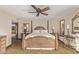 Bright bedroom with a decorative wooden bed frame, ceiling fan and tile floors for easy cleaning at 26405 S Lakewood Dr, Sun Lakes, AZ 85248