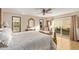 Elegant bedroom featuring tile floors, decorative mirror, ceiling fan and a glass door to the outdoor living space at 26405 S Lakewood Dr, Sun Lakes, AZ 85248