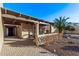 A side patio view with brick pavers, an overhang, desert landscaping, and a partial wall for privacy at 26405 S Lakewood Dr, Sun Lakes, AZ 85248