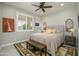 Bright bedroom featuring a ceiling fan, window with plantation shutters, and a cozy rug beneath the bed at 26578 W Piute Ave, Buckeye, AZ 85396