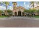 Exterior of clubhouse with well manicured landscaping, covered entrance, and tile roof at 26578 W Piute Ave, Buckeye, AZ 85396