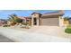 Charming single-story home featuring a two car garage, beautiful desert landscaping, and a stone facade at 26578 W Piute Ave, Buckeye, AZ 85396