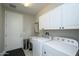 Well-equipped laundry room with white cabinets, sink, and modern washer and dryer at 26578 W Piute Ave, Buckeye, AZ 85396