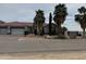 Beautiful single-story home showcasing desert landscaping and mature palm trees, enhancing its curb appeal at 2903 S 271St Ln, Buckeye, AZ 85326