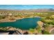 Stunning aerial view of a community lake with surrounding homes, lush landscaping, and mountain backdrop at 29304 N Horton Creek Trl, Rio Verde, AZ 85263