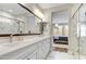 Bright bathroom featuring double sinks, white marble counters and tile, and a glass shower at 29304 N Horton Creek Trl, Rio Verde, AZ 85263