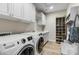 Well-equipped laundry room with modern washer and dryer, white cabinets, and ample storage space at 29304 N Horton Creek Trl, Rio Verde, AZ 85263