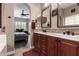 Ensuite bathroom with dual sinks, custom cabinetry, and arched entryway to primary bedroom at 3031 W Cottonwood Ln, Phoenix, AZ 85045