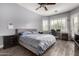 Comfortable bedroom featuring a ceiling fan, natural light, and hardwood floors at 3031 W Cottonwood Ln, Phoenix, AZ 85045