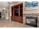 Cozy living room featuring built-in shelving, fireplace, tile floors and a large window at 3031 W Cottonwood Ln, Phoenix, AZ 85045