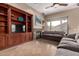 Cozy living room featuring built-in shelving, fireplace, tile floors and a large window at 3031 W Cottonwood Ln, Phoenix, AZ 85045