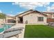 Relaxing backyard space featuring artificial turf, tanning lounges, and a pristine pool at 30480 N 128Th Ln, Peoria, AZ 85383