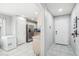 This entryway opens to a modern kitchen and dining area with light tile floors and bright white walls at 30480 N 128Th Ln, Peoria, AZ 85383