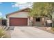 Charming home featuring a well-maintained yard, desert landscaping, and a prominent shade tree at 30480 N 128Th Ln, Peoria, AZ 85383