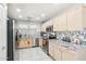 A view of the stainless steel appliances, light wood cabinets, and mosaic backsplash in this home's bright kitchen at 30480 N 128Th Ln, Peoria, AZ 85383