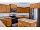 Kitchen with ample wood cabinetry, stainless steel appliances, and a central island for food prep at 342 E Backman St, San Tan Valley, AZ 85140