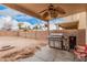 Backyard patio has ceiling fan, BBQ, smoker, and red chair seating at 38274 N Tumbleweed Ln, San Tan Valley, AZ 85140