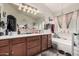 Bright bathroom featuring a large vanity and a soaking tub with a window for natural light at 38274 N Tumbleweed Ln, San Tan Valley, AZ 85140