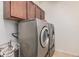 A laundry room with a washer, dryer, and upper cabinet for extra storage at 38274 N Tumbleweed Ln, San Tan Valley, AZ 85140