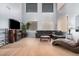 Bright living room with soaring ceilings, hardwood floors, and a comfortable black leather sectional at 38274 N Tumbleweed Ln, San Tan Valley, AZ 85140