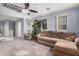 Cozy living room with plush carpeting, a comfortable sectional sofa, and plenty of natural light at 38274 N Tumbleweed Ln, San Tan Valley, AZ 85140