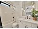 Bright bathroom featuring a shower-tub combo, black hardware, and modern vanity with pendant lighting at 3964 E Penedes Dr, Gilbert, AZ 85298