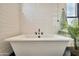 Bright bathroom with a soaking tub, hexagon tile floor, white subway tile walls, and a black faucet at 3964 E Penedes Dr, Gilbert, AZ 85298