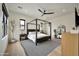 Stylish bedroom featuring a four-poster bed, shiplap accent wall, a ceiling fan, and black window frames at 3964 E Penedes Dr, Gilbert, AZ 85298