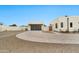 A modern home featuring a large garage door, a paved circular driveway, and desert landscaping at 3964 E Penedes Dr, Gilbert, AZ 85298