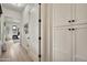 Hallway with a closet featuring flat-panel doors and hardware and an entry to a living room with a black-framed window at 3964 E Penedes Dr, Gilbert, AZ 85298