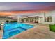 Backyard pool and spa with modern landscaping, creating a serene and luxurious outdoor space, set against a colorful evening sky at 3964 E Penedes Dr, Gilbert, AZ 85298