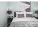 Relaxing bedroom featuring grey bedding, a bedside table, and natural light at 402 E Muriel Dr, Phoenix, AZ 85022