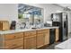 Well-lit kitchen showcasing ample counter space, wood cabinetry, stainless steel appliances, and a bright window at 402 E Muriel Dr, Phoenix, AZ 85022