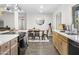 Bright kitchen and dining area with stainless steel appliances, light wood cabinets, and modern lighting at 402 E Muriel Dr, Phoenix, AZ 85022