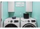 Bright laundry room features modern washer and dryer, white cabinetry and cute 'Laundry Loads of Fun' sign at 402 E Muriel Dr, Phoenix, AZ 85022