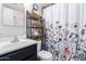 Bathroom featuring a floral shower curtain, dark vanity, and decorative shelving at 4202 N 74Th Dr, Phoenix, AZ 85033