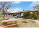 Charming single-story home featuring lush landscaping, a cozy bench, and secure gated access to the carport at 4202 N 74Th Dr, Phoenix, AZ 85033