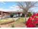 Charming single-story home featuring lush landscaping, a cozy bench, and secure gated access to the carport at 4202 N 74Th Dr, Phoenix, AZ 85033