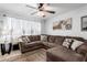 Bright living room with a large sectional sofa, ceiling fan, and motorcycle wall art at 4202 N 74Th Dr, Phoenix, AZ 85033